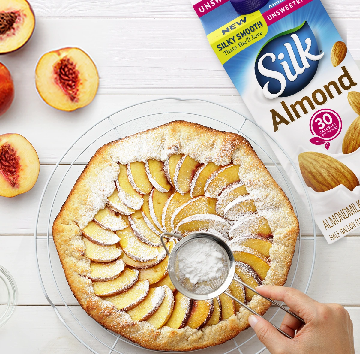 Silk Almond campaign artwork showing a peach cake and a carton of almondmilk